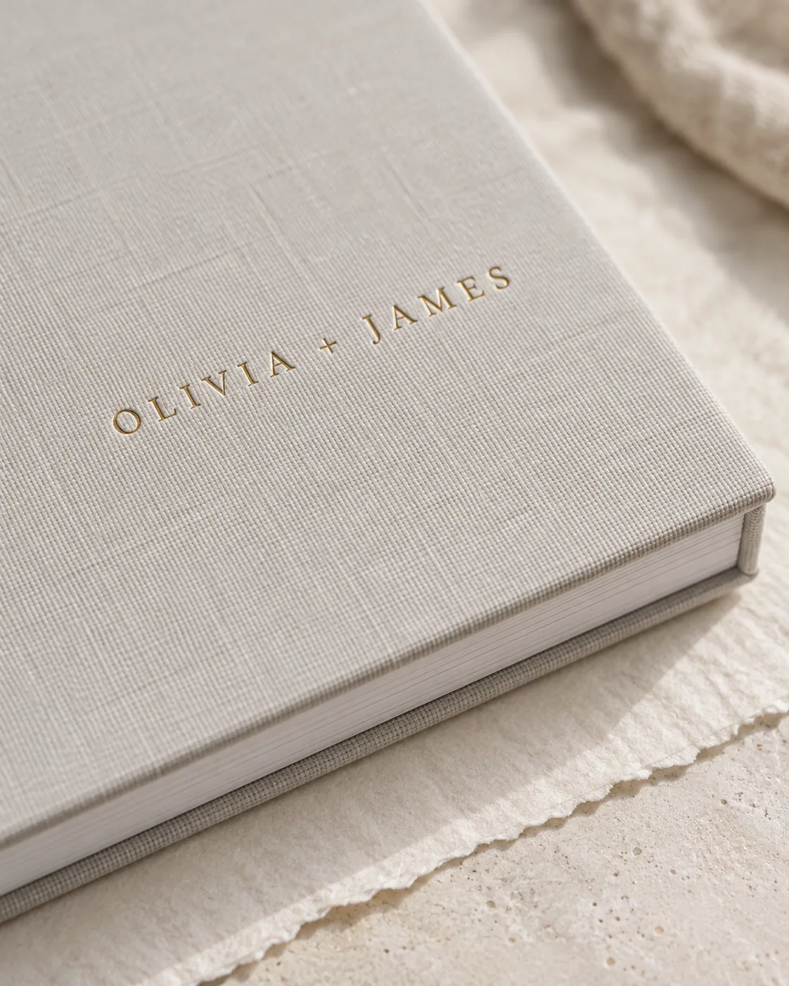 Close-up of a linen album cover debossed with the couple's names